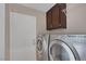 Efficient laundry room with modern washer and dryer units, with cabinet storage above at 301 Montcliff Ave, Henderson, NV 89074