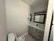 Bright bathroom featuring gray vanity, mirror and toilet at 325 Greenfield Ln, Las Vegas, NV 89107