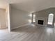 Bright living room with vaulted ceilings, a cozy fireplace, and modern gray floors at 325 Greenfield Ln, Las Vegas, NV 89107