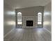 Inviting living room featuring a fireplace, arched windows, and stylish gray flooring at 325 Greenfield Ln, Las Vegas, NV 89107