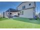 A full backyard with covered patio featuring a fireplace, tv, and comfortable seating with well-kept artificial grass at 3264 Monte Luna Ave, Henderson, NV 89044