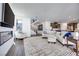 Open-concept living space with white sofa, fireplace, and access to kitchen and staircase at 3264 Monte Luna Ave, Henderson, NV 89044