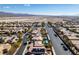 Large desert community featuring well maintained homes with solar panels on roofs, under a bright blue sky at 3829 Hawkeye Falls Ave, North Las Vegas, NV 89085