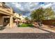 Spacious backyard featuring a brick patio, lush green turf, mature landscaping, and cozy hanging chair at 3829 Hawkeye Falls Ave, North Las Vegas, NV 89085
