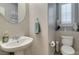 Neat half bathroom with a vessel sink, round mirror, toilet, and a plantation shuttered window at 3829 Hawkeye Falls Ave, North Las Vegas, NV 89085