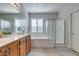 A bright bathroom featuring a large mirror, dual sinks, and separate tub and shower at 3829 Hawkeye Falls Ave, North Las Vegas, NV 89085