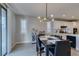 Bright dining area features modern chandelier, seamlessly connecting to kitchen with sleek white cabinetry at 3829 Hawkeye Falls Ave, North Las Vegas, NV 89085