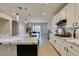 Bright, modern kitchen boasts white cabinets, sleek black hardware, and a stunning island with waterfall countertops at 3829 Hawkeye Falls Ave, North Las Vegas, NV 89085