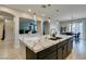 Modern kitchen island boasts marble countertops, gold fixtures, and pendant lighting, flowing into the dining area at 3829 Hawkeye Falls Ave, North Las Vegas, NV 89085