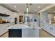 Modern kitchen featuring a large island, stylish lighting fixtures, and stainless steel appliances at 3829 Hawkeye Falls Ave, North Las Vegas, NV 89085