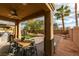Covered outdoor dining area with ceiling fan, built-in grill, and a view of the manicured backyard at 3829 Hawkeye Falls Ave, North Las Vegas, NV 89085