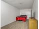 Simple bedroom with wood floors featuring a bed with red blanket and a TV on a dresser at 4156 Broadriver Dr, Las Vegas, NV 89108