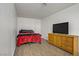 Bedroom with wood floors and a bed with red blanket next to a wooden dresser at 4156 Broadriver Dr, Las Vegas, NV 89108