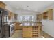 Bright kitchen features wood cabinets, granite countertops, stainless steel appliances, and a central island with wine rack at 4156 Broadriver Dr, Las Vegas, NV 89108