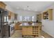 Bright kitchen features wood cabinets, granite countertops, stainless steel appliances, and a central island with wine rack at 4156 Broadriver Dr, Las Vegas, NV 89108