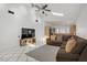 Open-concept living area with a brown sectional, white tile floors, and a view into the kitchen at 4156 Broadriver Dr, Las Vegas, NV 89108