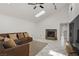 Bright living room features a brick fireplace, vaulted ceilings, tile flooring, and plush seating at 4156 Broadriver Dr, Las Vegas, NV 89108