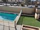 A pristine pool is surrounded by neat artificial turf and brick planter boxes, offering a serene outdoor experience at 4417 De Forest St, Las Vegas, NV 89103