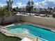 A spacious backyard featuring a sparkling pool, secured with white fencing, and framed by verdant artificial turf at 4417 De Forest St, Las Vegas, NV 89103