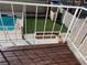 A tranquil backyard with a refreshing pool, inviting green artificial turf, and a quaint brick fire pit area at 4417 De Forest St, Las Vegas, NV 89103