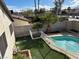 An inviting backyard features a sparkling pool, lush artificial turf, complemented by mature landscaping for added privacy at 4417 De Forest St, Las Vegas, NV 89103