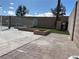 Backyard with a pool, concrete patio, artificial grass, and a built-in brick firepit area at 4417 De Forest St, Las Vegas, NV 89103