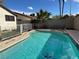 Relaxing backyard featuring a pristine pool and lush artificial turf for low-maintenance outdoor living at 4417 De Forest St, Las Vegas, NV 89103