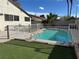 Backyard view of a fenced-in pool surrounded by lush artificial turf with ample space for outdoor enjoyment at 4417 De Forest St, Las Vegas, NV 89103