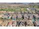 Expansive aerial shot of a residential area adjacent to a golf course with mountain views and well-kept landscaping at 505 Punto Vallata Dr, Henderson, NV 89011