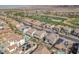 Lovely aerial view of houses with solar panels near a lush golf course, blending eco-friendly living with recreation at 505 Punto Vallata Dr, Henderson, NV 89011