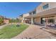 Large backyard with brick patio, artificial grass, a play structure, and sliding doors leading inside at 505 Punto Vallata Dr, Henderson, NV 89011