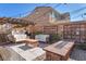 Relaxing backyard sitting area with a custom fire pit, comfortable seating, and privacy walls with climbing vines at 505 Punto Vallata Dr, Henderson, NV 89011