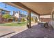 Enjoyable backyard area with synthetic grass, brick patio, dining table, garden beds and covered patio at 505 Punto Vallata Dr, Henderson, NV 89011