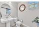 Bathroom featuring a pedestal sink, round decorative mirror, tile floors and paint in a neutral color scheme at 505 Punto Vallata Dr, Henderson, NV 89011