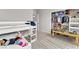Neutral room with a bunk bed and patterned rug, featuring an organized closet with shelving for clothing and toys at 505 Punto Vallata Dr, Henderson, NV 89011