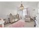 Charming Bedroom with a crib, chandelier, plush rug, and comfortable seating for a cozy haven at 505 Punto Vallata Dr, Henderson, NV 89011