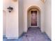 Inviting entryway with a decorative wreath, arched entryway and a brick walkway at 505 Punto Vallata Dr, Henderson, NV 89011