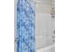 Bright shower and bathtub with a patterned blue curtain and white tile walls for a clean design at 505 Punto Vallata Dr, Henderson, NV 89011