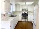 Well-lit kitchen featuring white cabinetry, tiled backsplash, and stainless steel appliances at 5117 Eldora Ave # 4, Las Vegas, NV 89146
