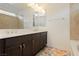 Well-lit bathroom boasts a double sink vanity with neutral countertops and decorative wall mirror at 5384 Knitmore Ct, Las Vegas, NV 89139