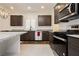 Modern kitchen with stainless steel appliances, granite countertops, and dark wood cabinets at 5384 Knitmore Ct, Las Vegas, NV 89139