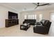 Spacious living room with wood floors, ceiling fan, and comfortable leather seating at 5384 Knitmore Ct, Las Vegas, NV 89139