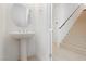 Clean powder room with pedestal sink and easy access to the nearby staircase at 5384 Knitmore Ct, Las Vegas, NV 89139