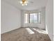 Unfurnished bedroom featuring a ceiling fan, a bay window, and neutral carpet at 5401 Tassara Way # 102, Las Vegas, NV 89108
