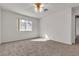 Bedroom featuring neutral carpet, a large window, and a ceiling fan at 5401 Tassara Way # 102, Las Vegas, NV 89108