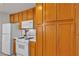 Well-lit kitchen featuring white appliances, tile countertops, and ample wood cabinet storage space at 5401 Tassara Way # 102, Las Vegas, NV 89108