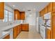 Bright kitchen with white appliances, tile floors, wood cabinets, and an adjacent dining area at 5401 Tassara Way # 102, Las Vegas, NV 89108