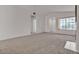 Spacious living room with plush carpeting and lots of natural light from a large window at 5401 Tassara Way # 102, Las Vegas, NV 89108