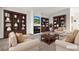 Staged living room with custom bookshelves, comfortable seating, and a fireplace feature at 5401 Tassara Way # 102, Las Vegas, NV 89108