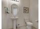 This half-bath features a pedestal sink, an oval mirror, and modern artwork at 5518 Taylor Rose Ave, Las Vegas, NV 89139